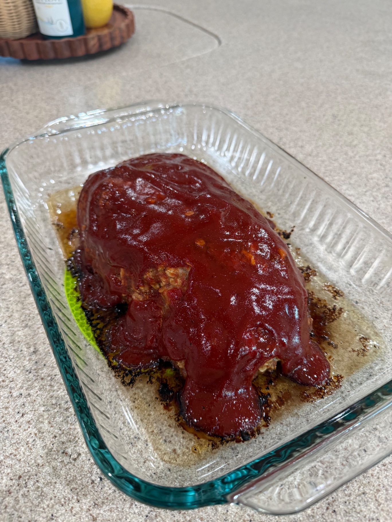 Whole glazed meatloaf in a glass baking dish fresh from the oven.