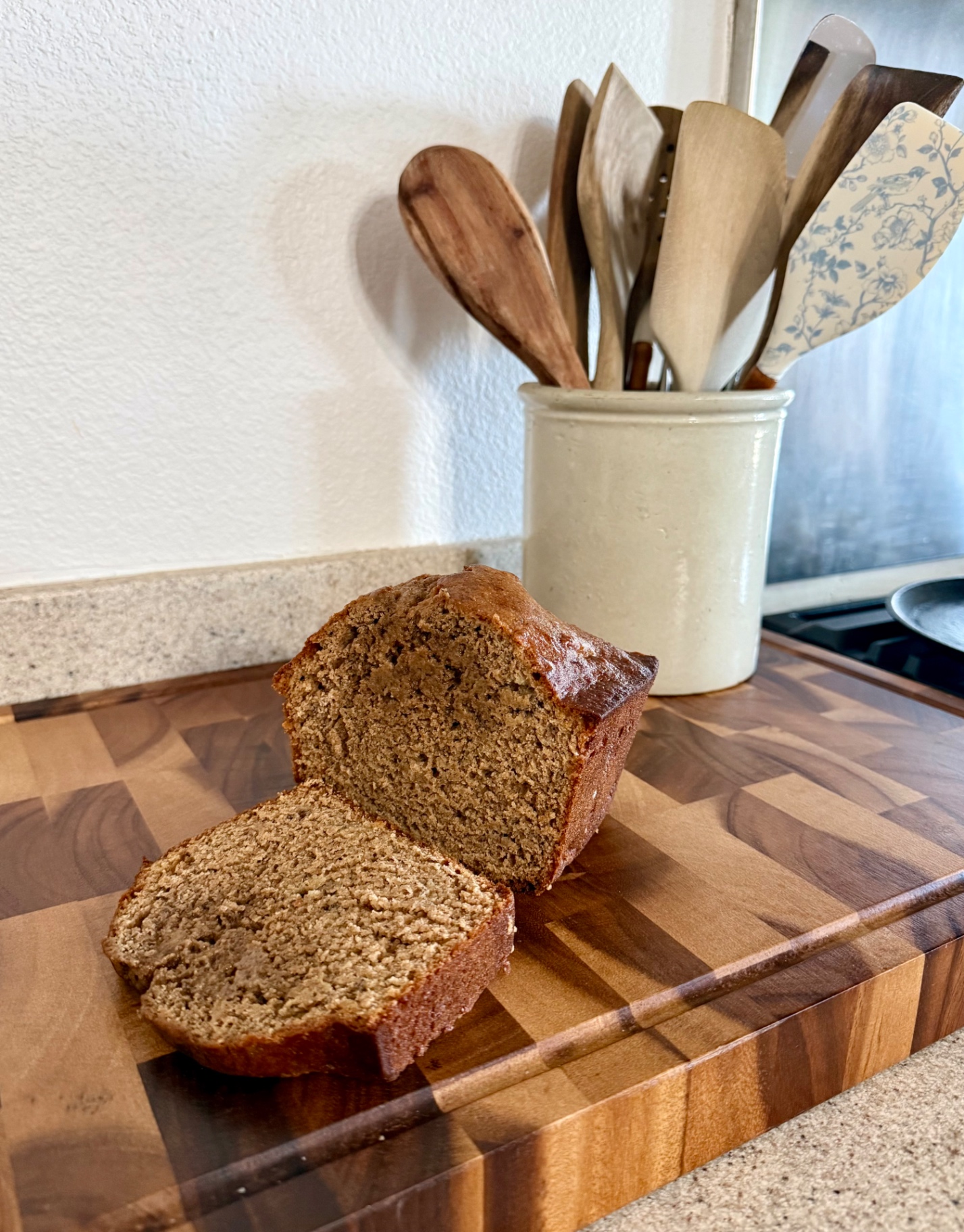 Sliced cinnamon applesauce banana bread on a wooden board