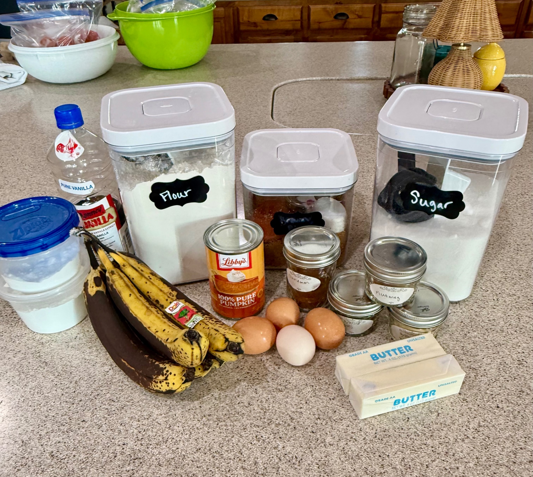 Ingredients for homemade banana pumpkin bread including ripe bananas, pumpkin puree, eggs, butter, flour, sugar, vanilla, and warm spices.