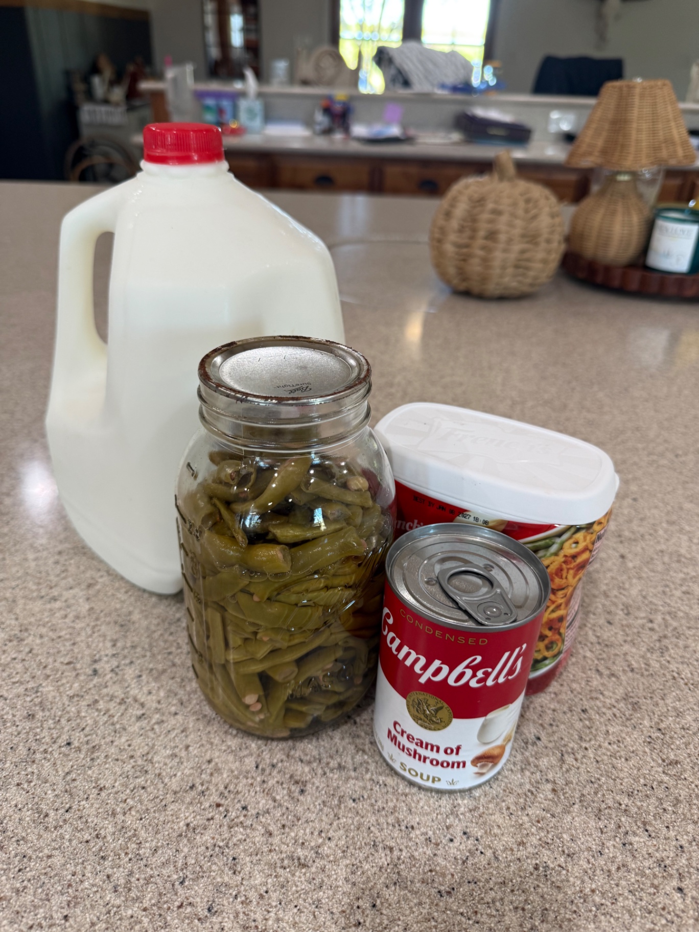 Green beans, cream of mushroom soup, milk, and crispy fried onions on the kitchen counter.