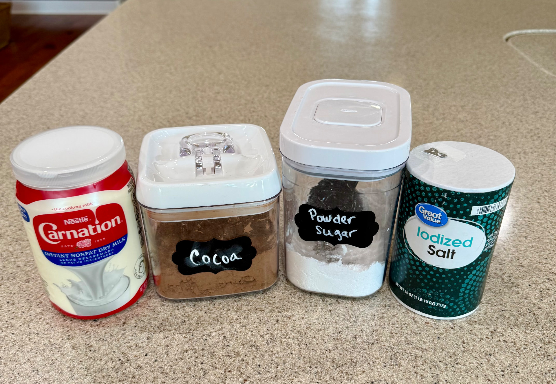 Carnation instant nonfat dry milk, cocoa powder, powdered sugar, and salt on the kitchen counter.