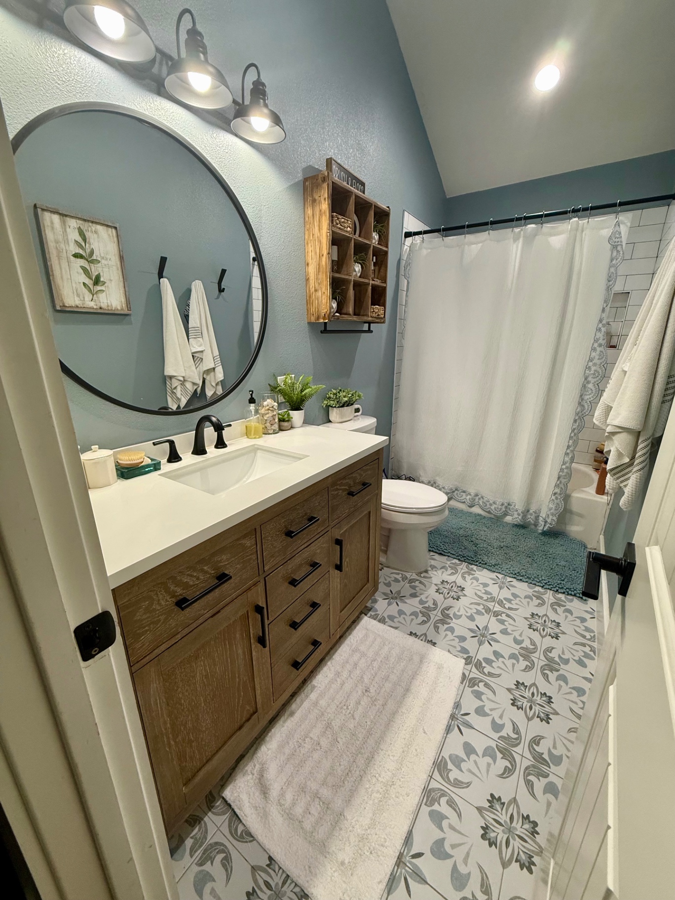 Finished clean bathroom with fresh towels, patterned tile floor, and clear counter
