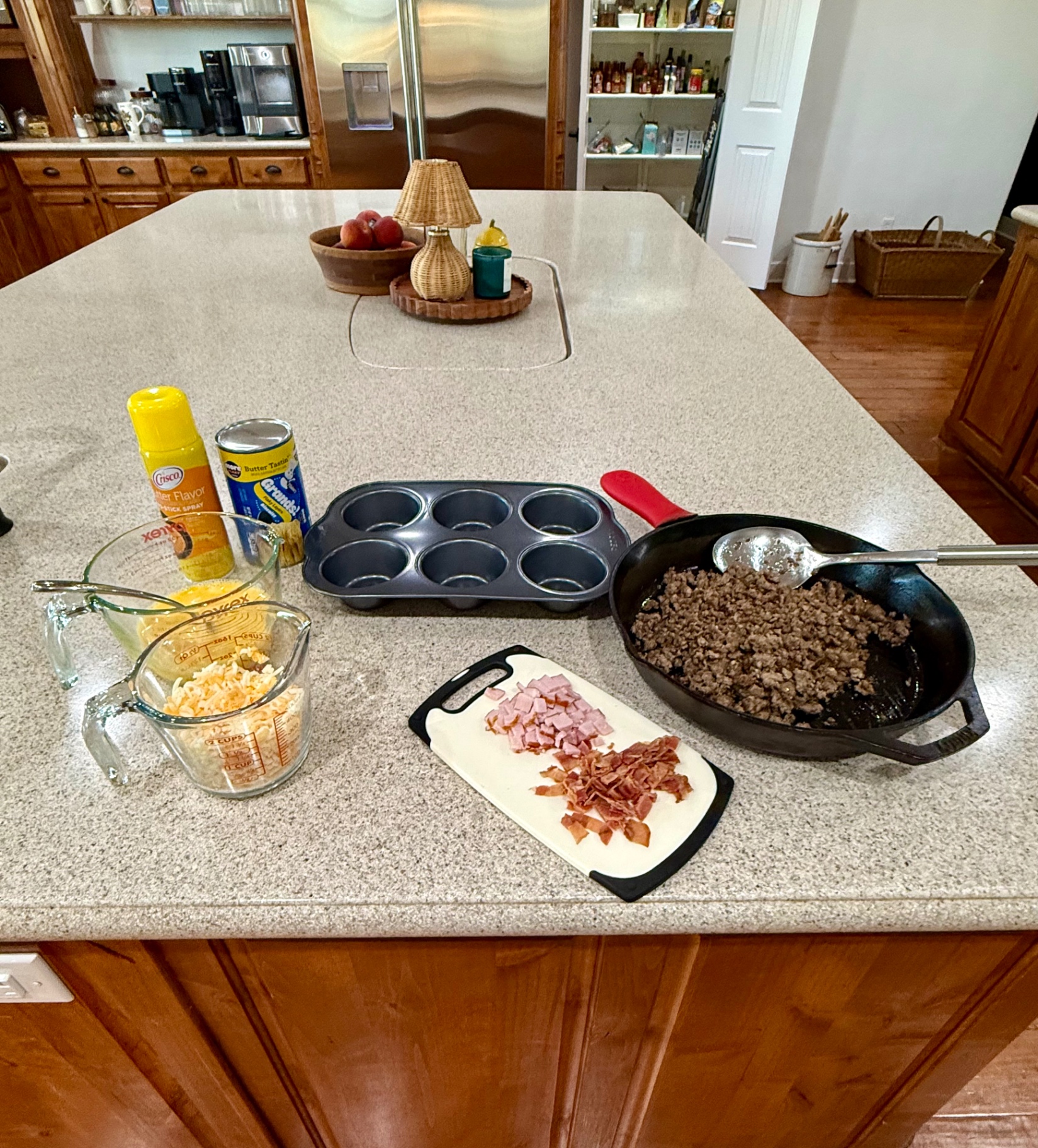 Flaky biscuits, eggs, shredded cheese, bacon, ham, and sausage for loaded breakfast biscuits.