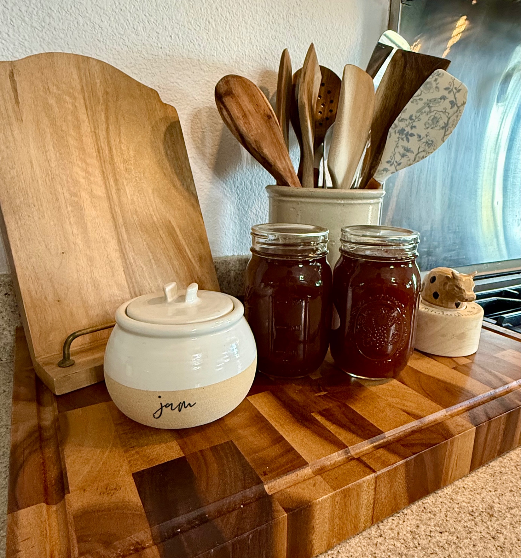 Jars of plum jam beside the pot the jam was cooked in