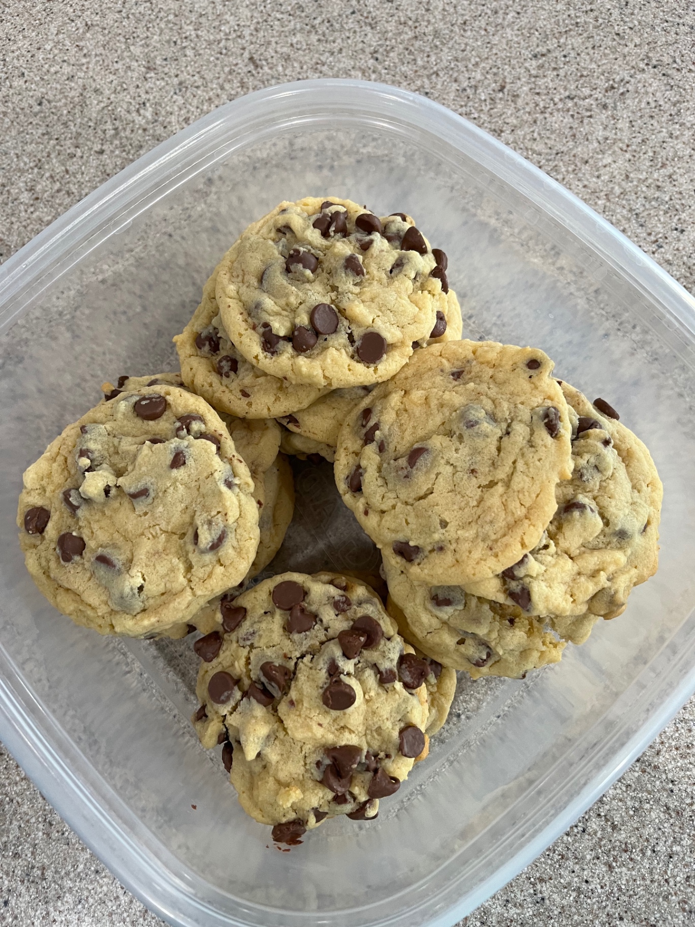 A container of thick, soft homemade chocolate chip cookies
