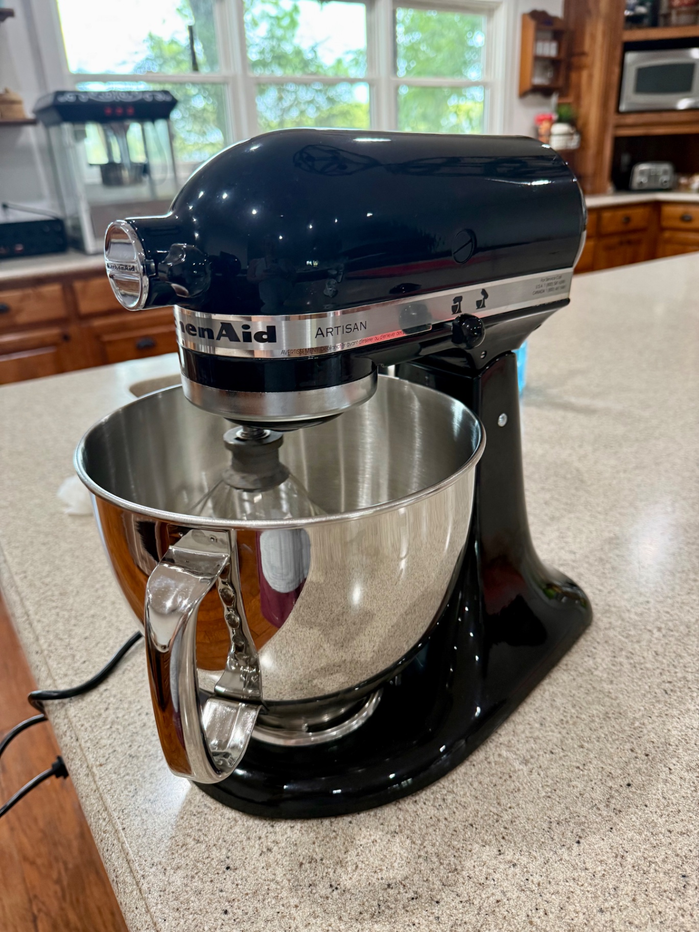 Black KitchenAid Artisan stand mixer with stainless steel mixing bowl on a kitchen counter