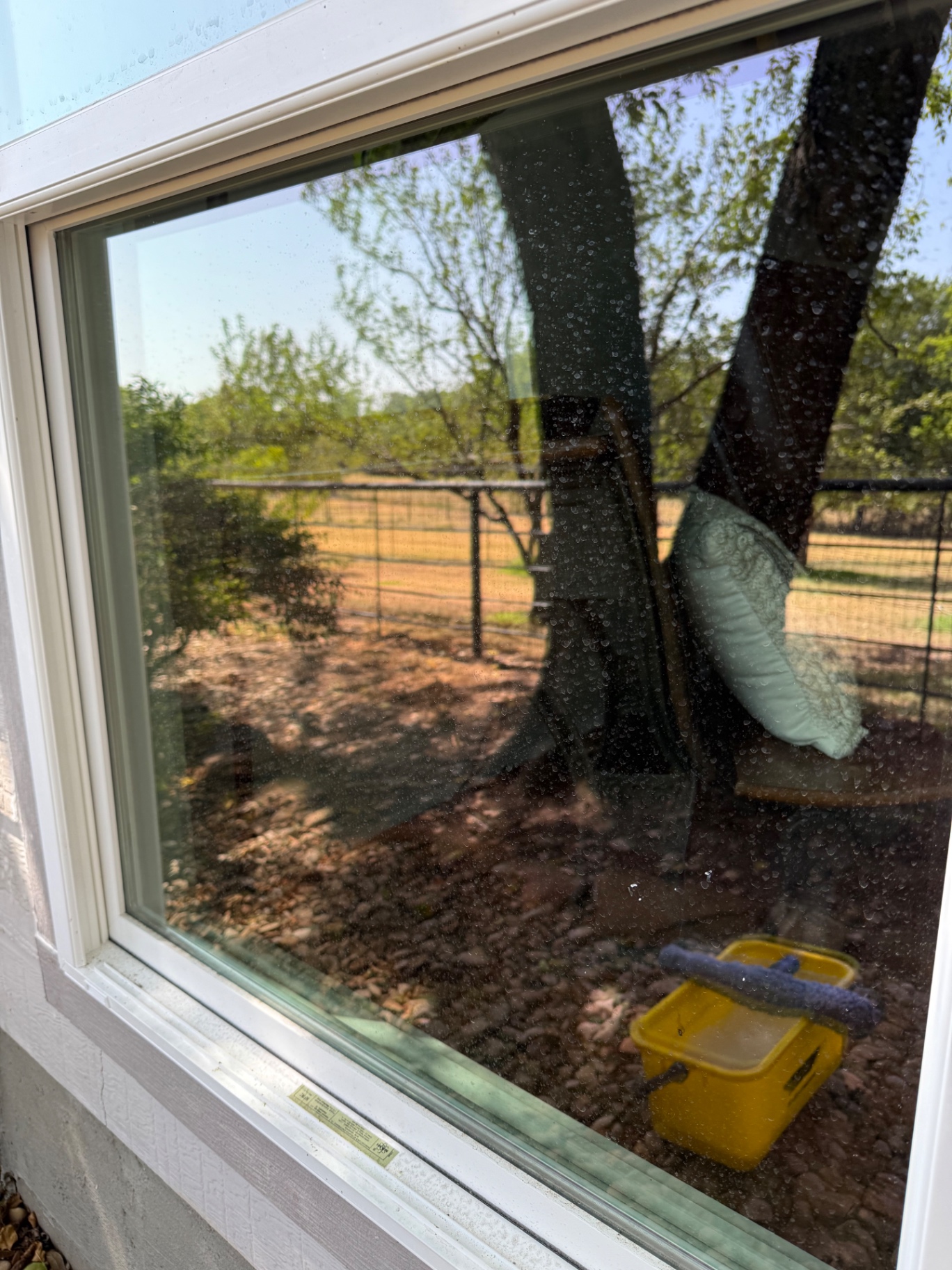 Window with visible water spots and outdoor grime before cleaning.