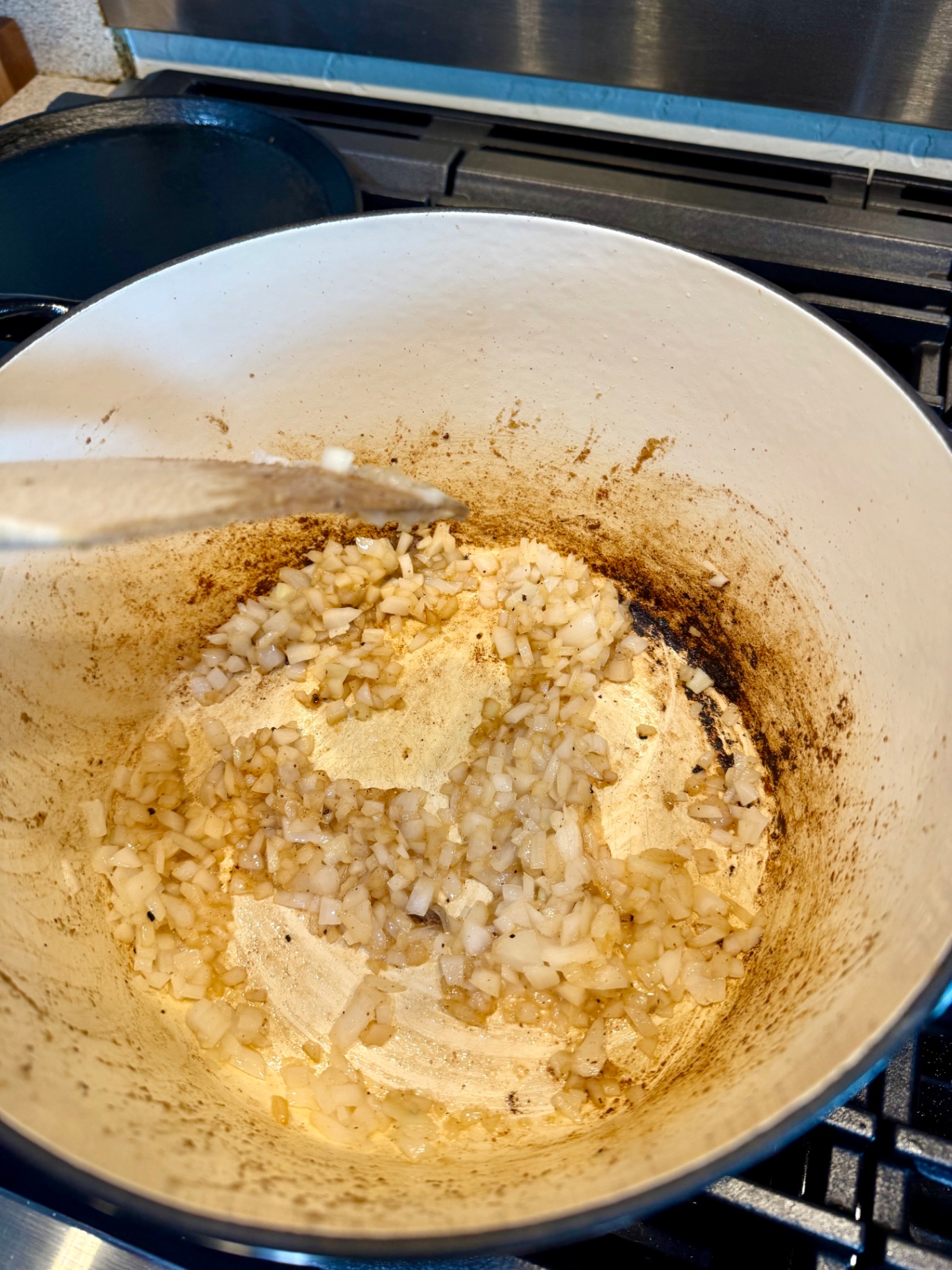 Diced onion and garlic cooking in the same Dutch oven used to brown the beef.
