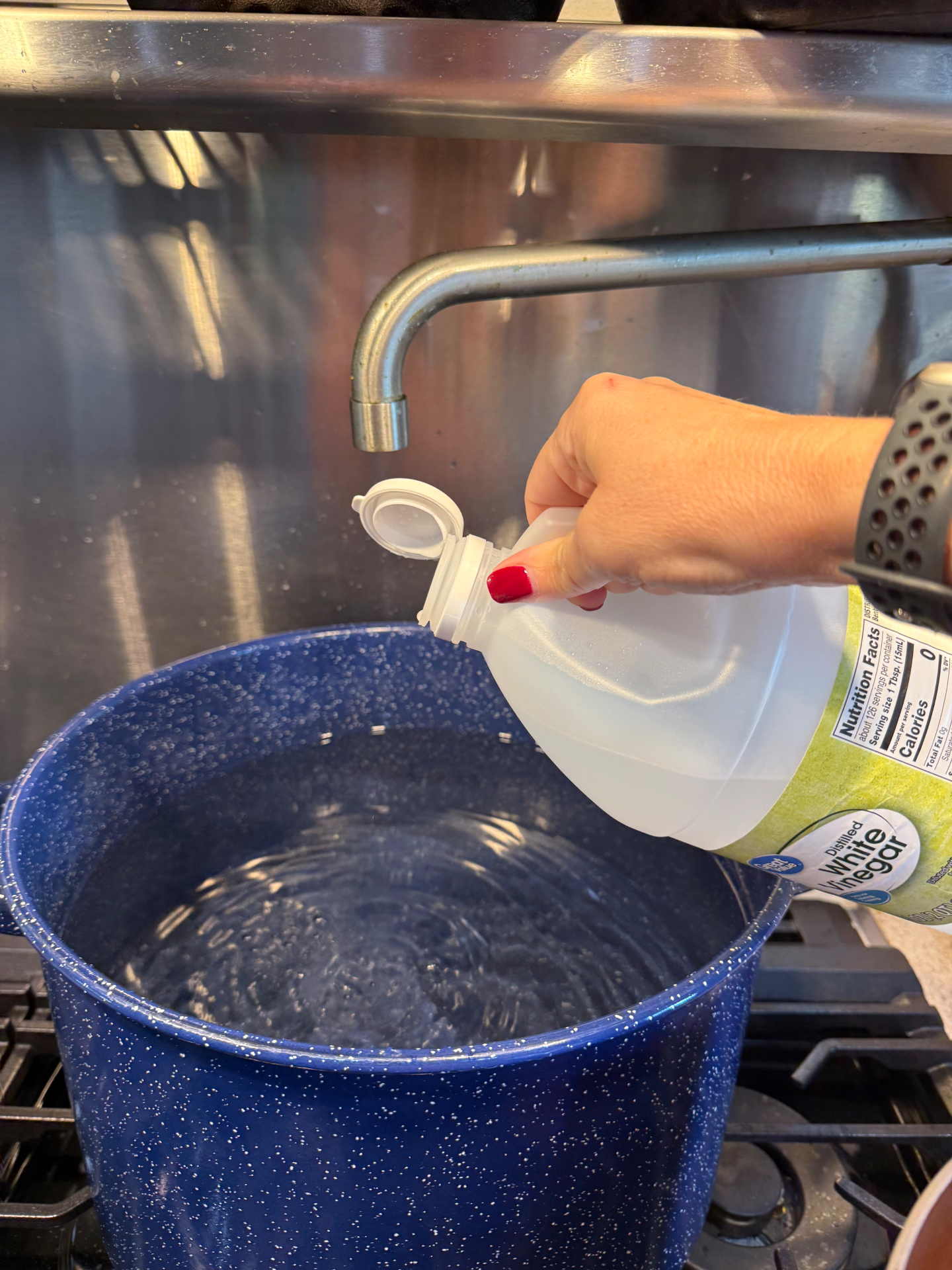 Adding a small amount of distilled white vinegar to the water in a canning pot.
