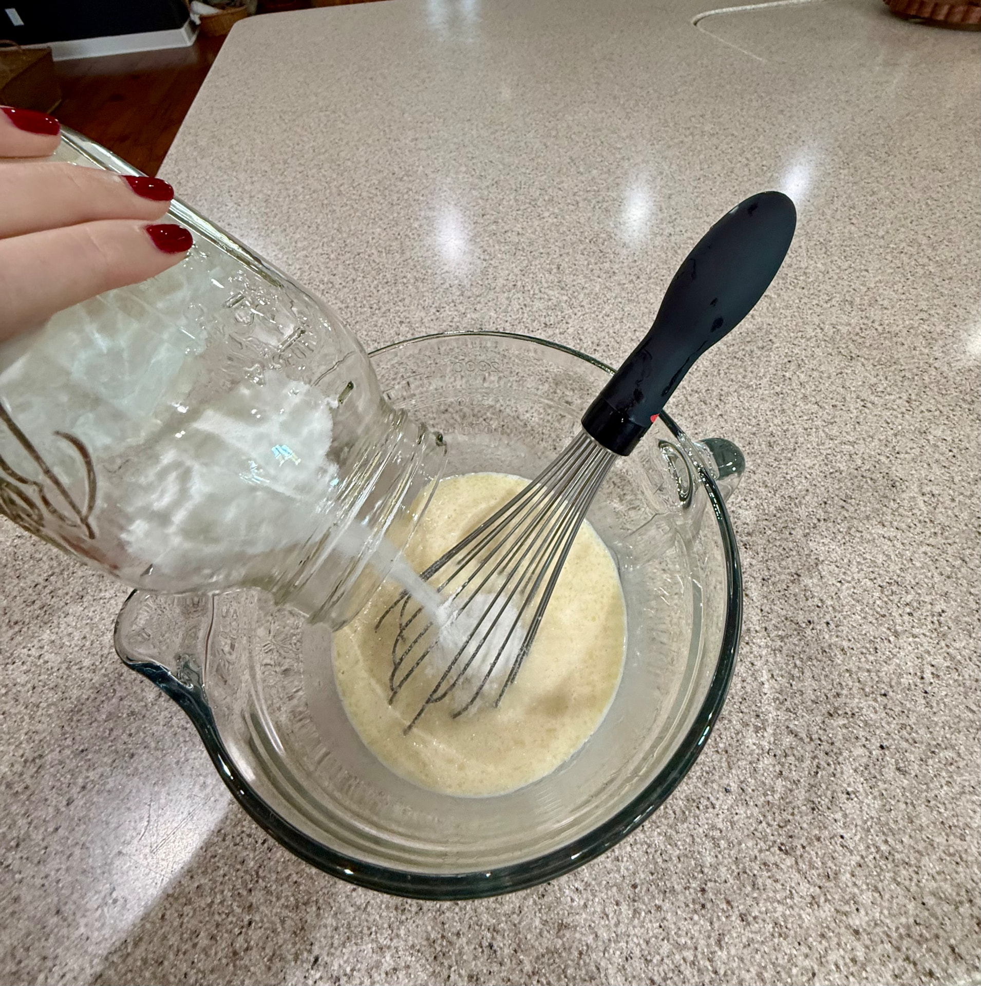 Pouring the dry pancake mix from the mason jar into a mixing bowl.
