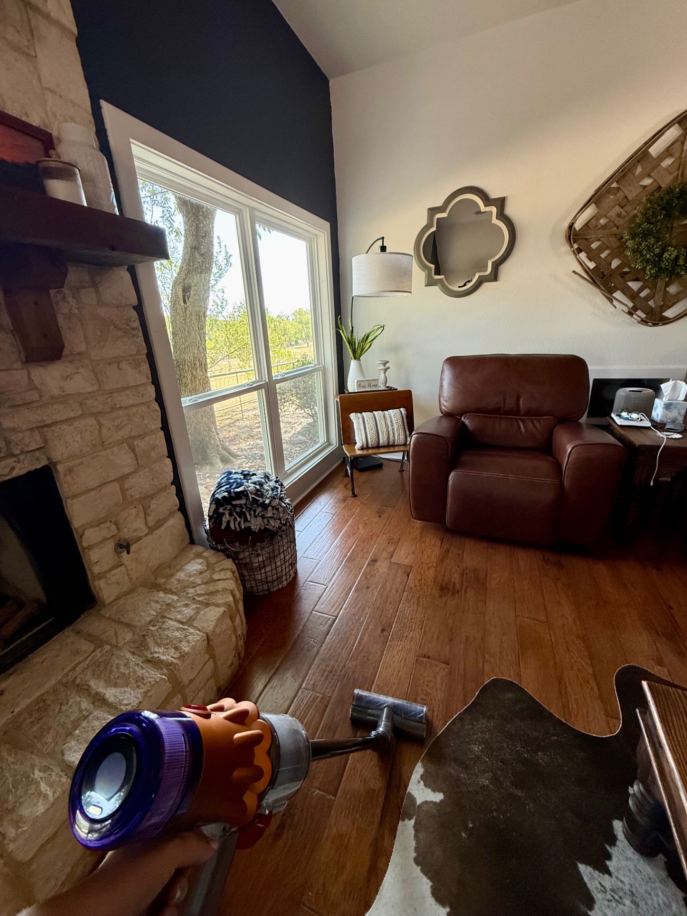 Vacuuming hardwood floors in the living room with a cordless stick vacuum