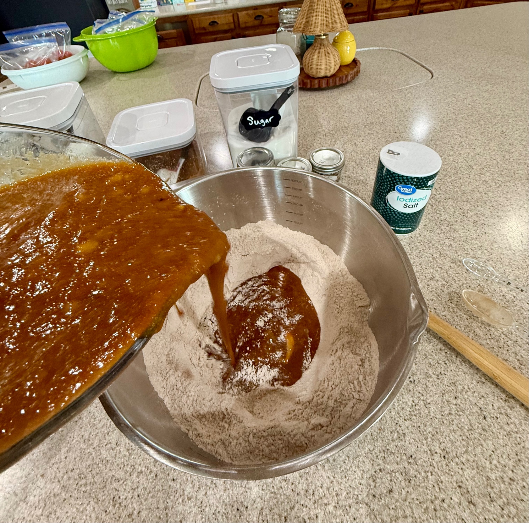 Banana pumpkin mixture being poured into dry ingredients for banana pumpkin bread batter.