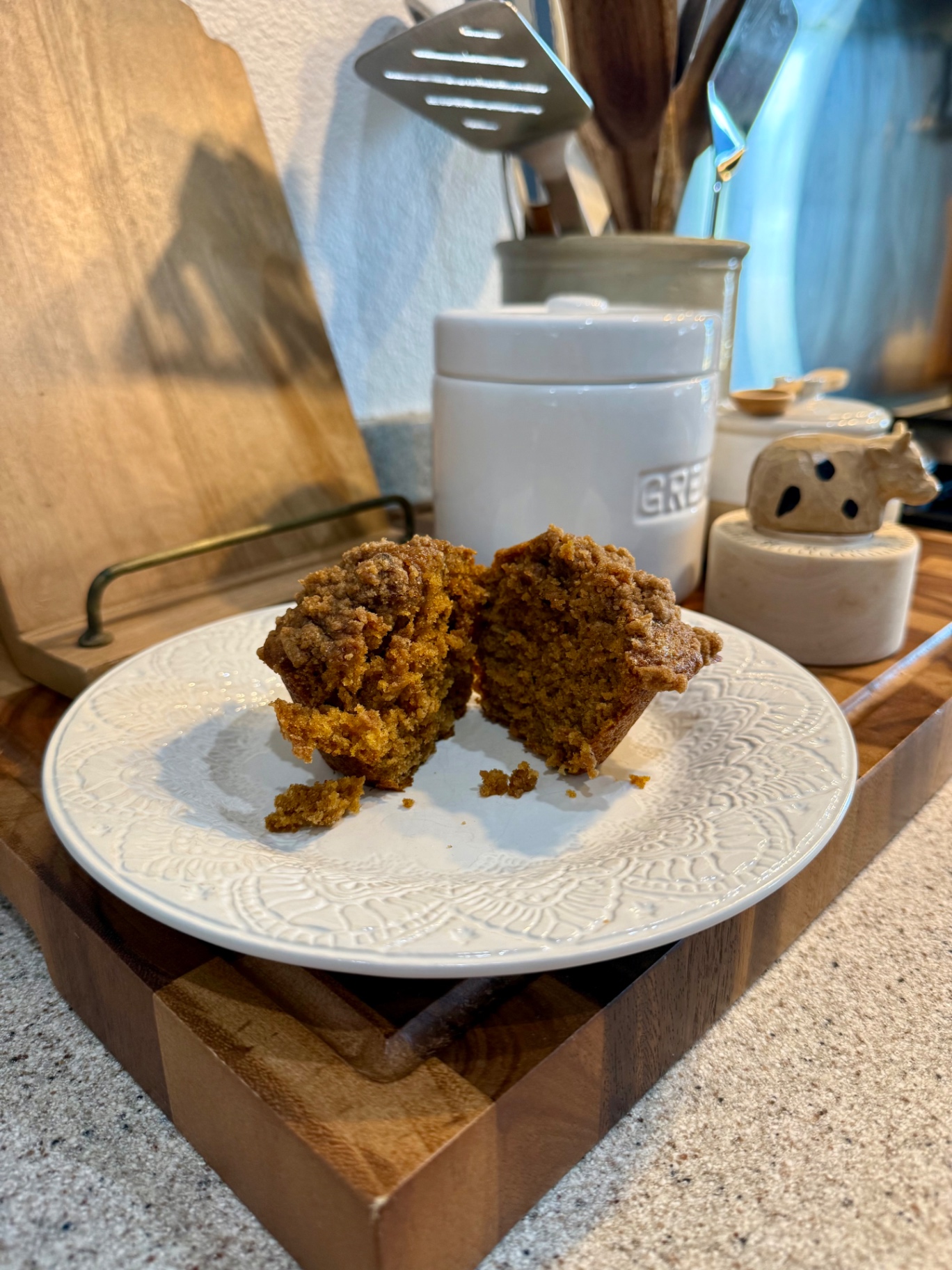 Banana pumpkin muffin split open to show the soft interior and cinnamon crumble topping.
